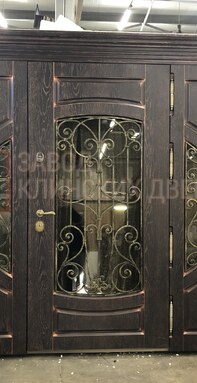 массивная двухстворчатая входная дверь с отделкой под старину и фигурной ковкой